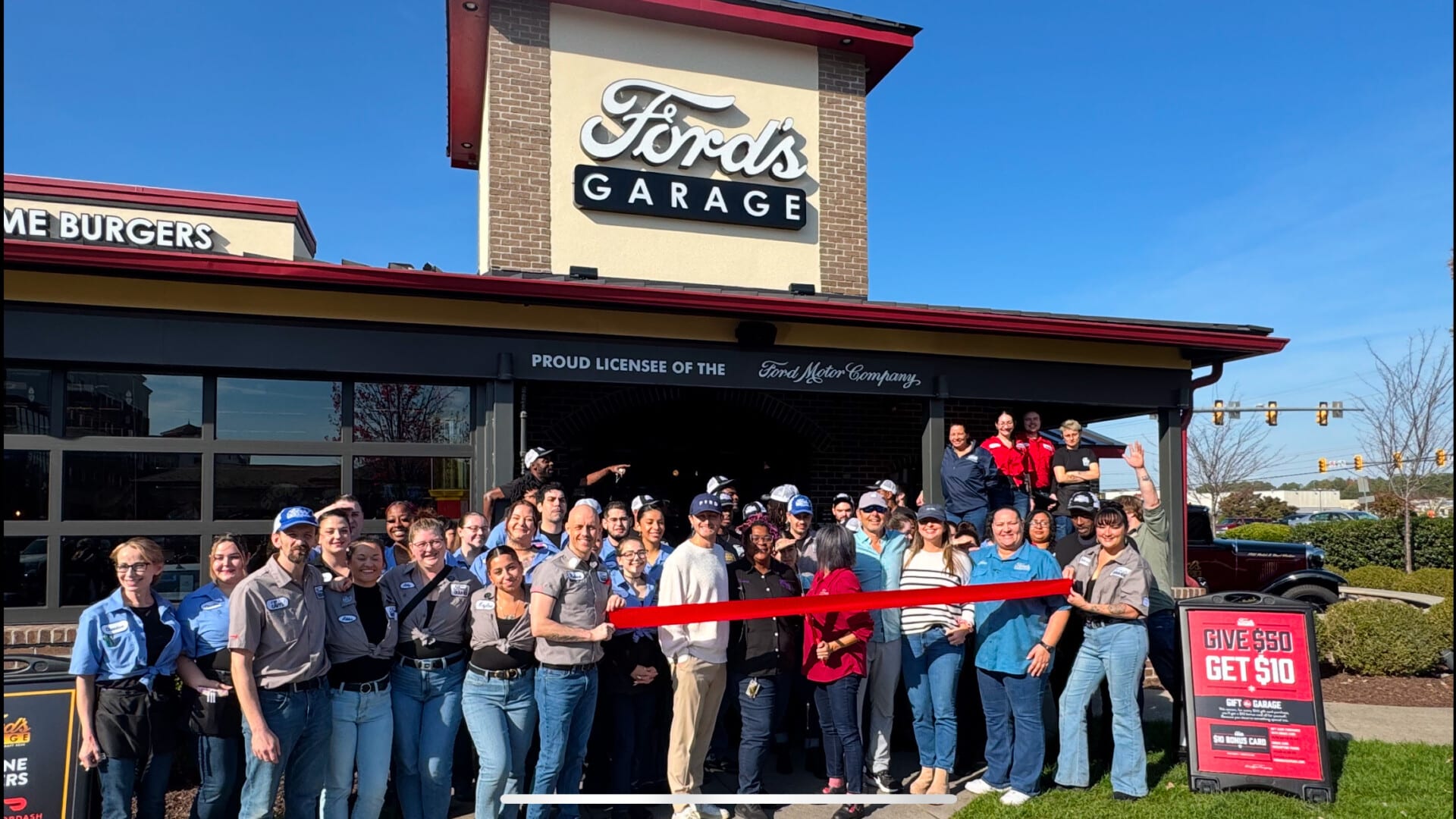 group of people cutting ribbon in front of building